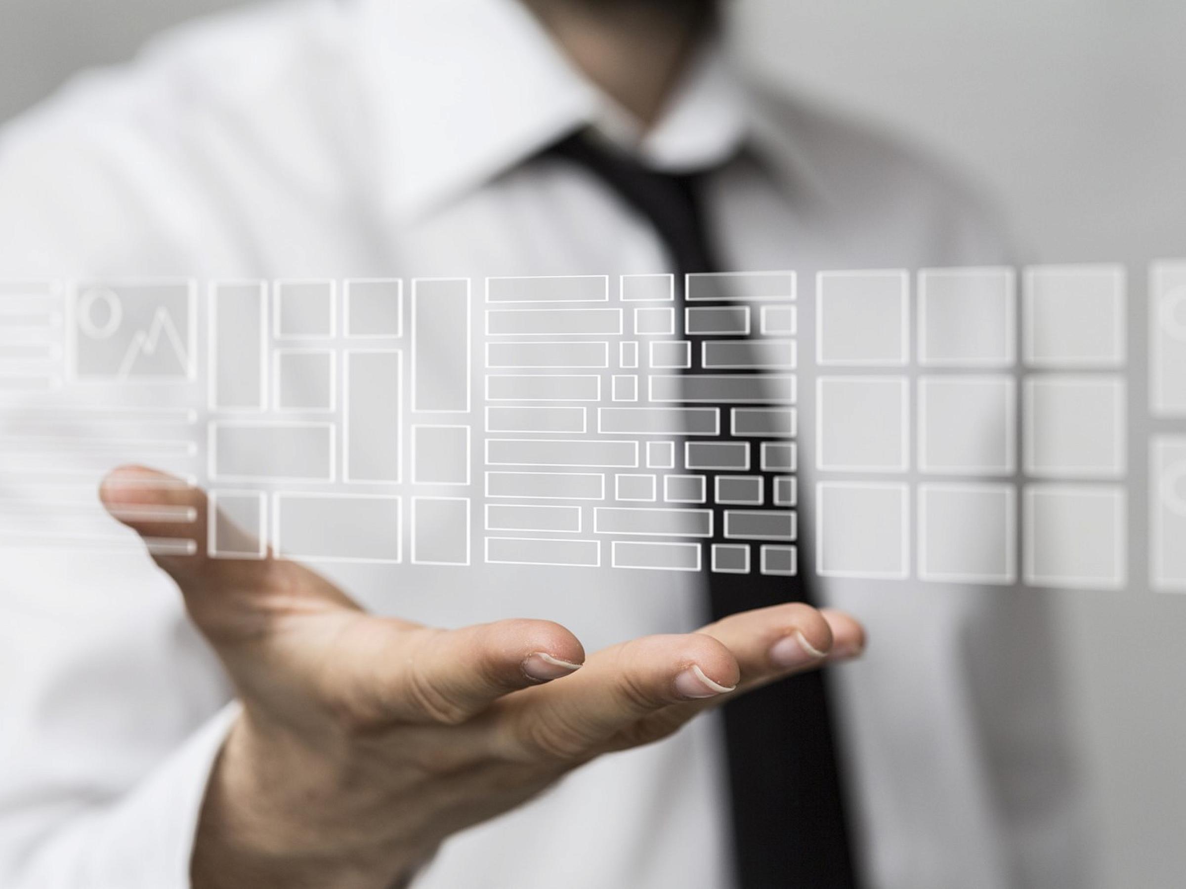Man holds out hand with digital image above it.